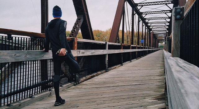 Runner stretching on bridge