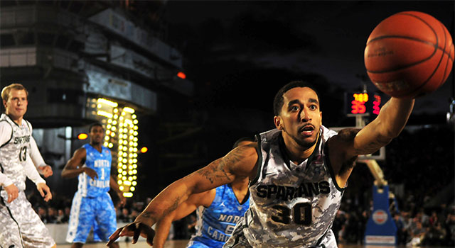 man playing basketball almost drops ball
