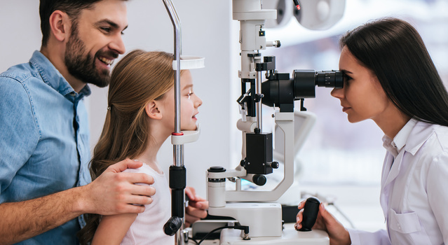 Dad with daughter in ophthalmology clinic