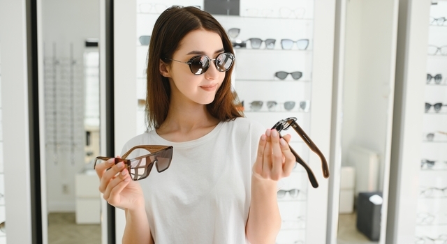young woman choosing a new pair of sunglasses