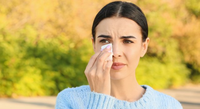 Young woman suffering from allergy outdoors