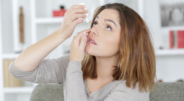 young woman applying eye drops for dry eyes
